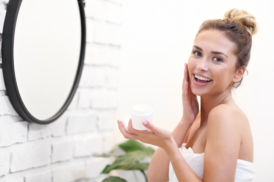 mujer aplicando crema hidratante en su rostro después de una doble limpieza facial