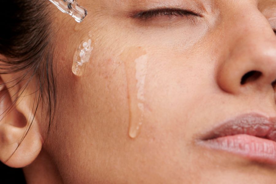 mujer aplica serum en su rostro